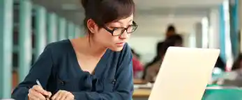 student reading from laptop